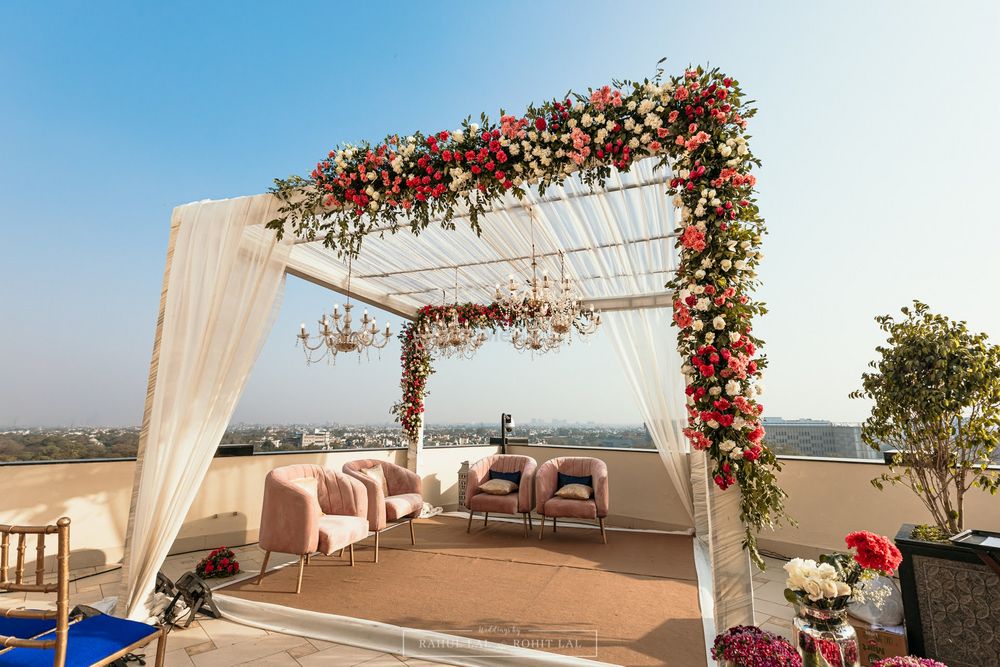 Photo of Pretty and minimal mandap décor with floral arrangements for a rooftop wedding.