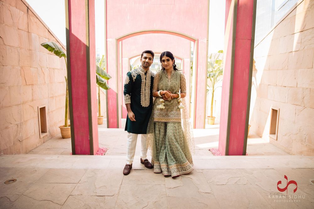 Photo of Bride and groom dressed in shades of green.