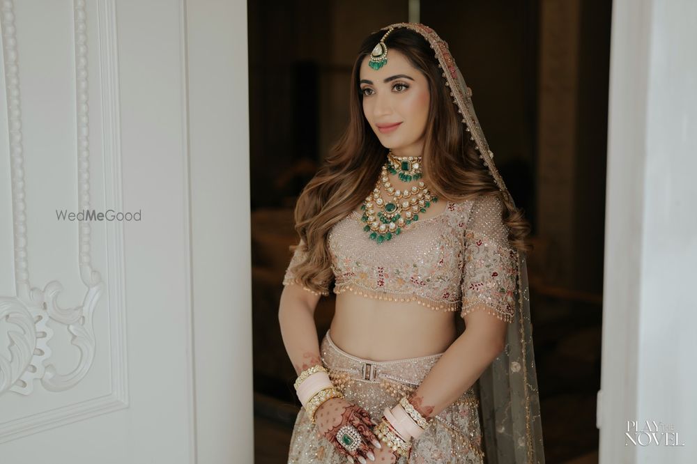 Photo of Timeless bridal portrait with bride in a pastel lehenga, open hairdo and  belt style lehenga on her wedding day
