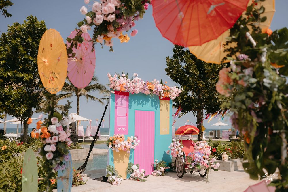 Photo of Colourful photobooth with parasols and florals for an outdoor mehendi