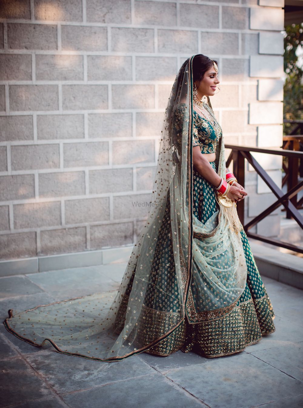 Photo of A bride in a green lehenga with a contrasting dupatta