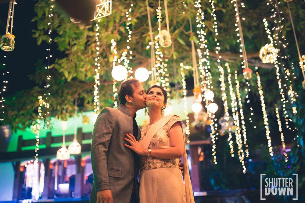 Photo of Bride and groom under fairy lights