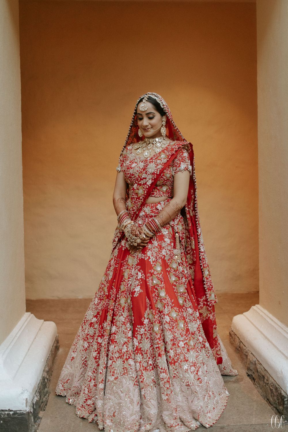 Photo of tomato red anamika khanna bridal lehenga on bride