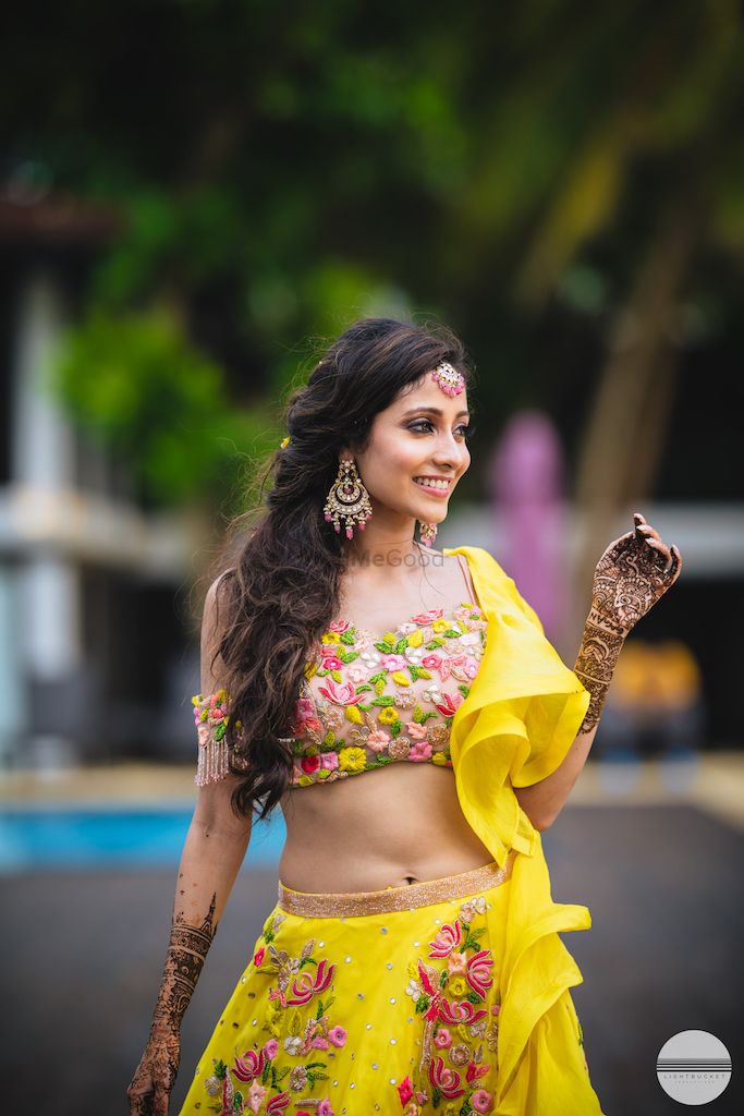 Photo of A bride to be on her mehendi day in yellow lehenga