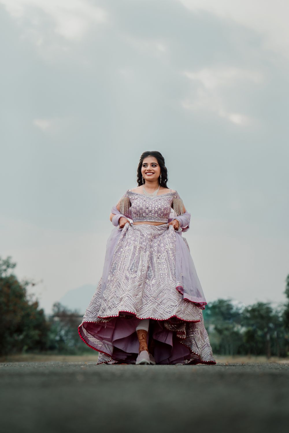 Photo of bride wearing lavender lehenga and sneakers for engagement