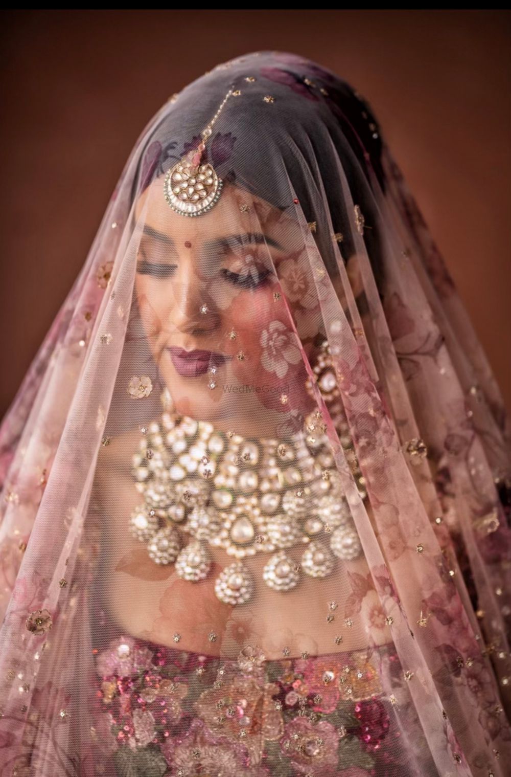Photo of pretty bridal shot with a printed dupatta as veil