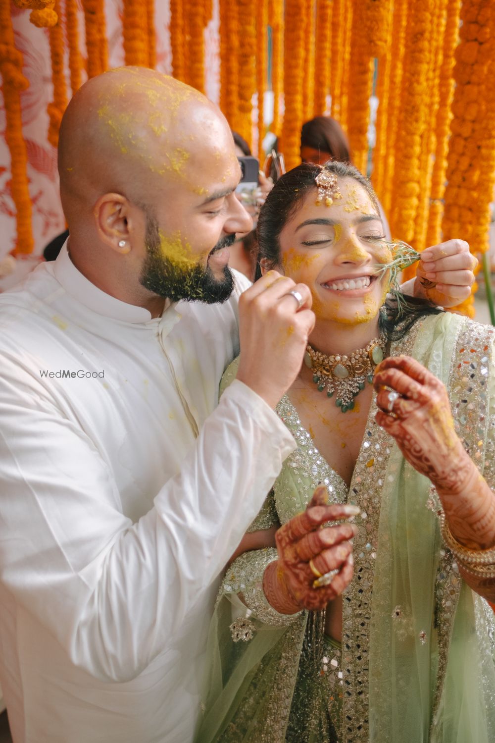 Photo of Lovely couple photo on haldi day with bride in a mint green lehenga with mirrorwork