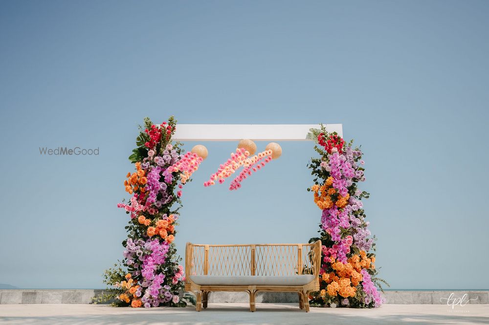 Photo of Colourful mehendi decor for an outdoor event with a rattan sofa