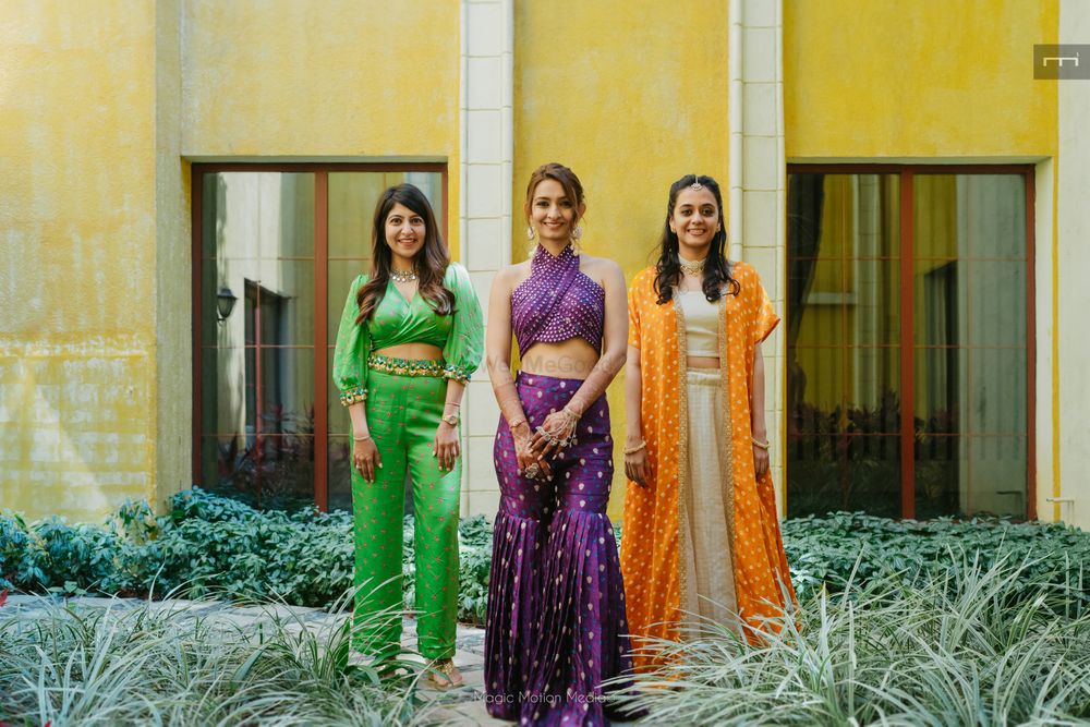 Photo of Stunning bridesmaids and bridal portrait with bride in a co-ordinated set with fun sharara pants and a halter neck blouse in aubergine