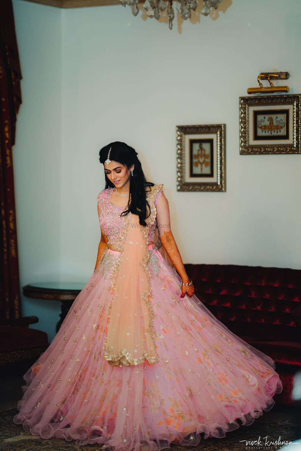 Photo of Bride twirling in her light pink engagement lehenga