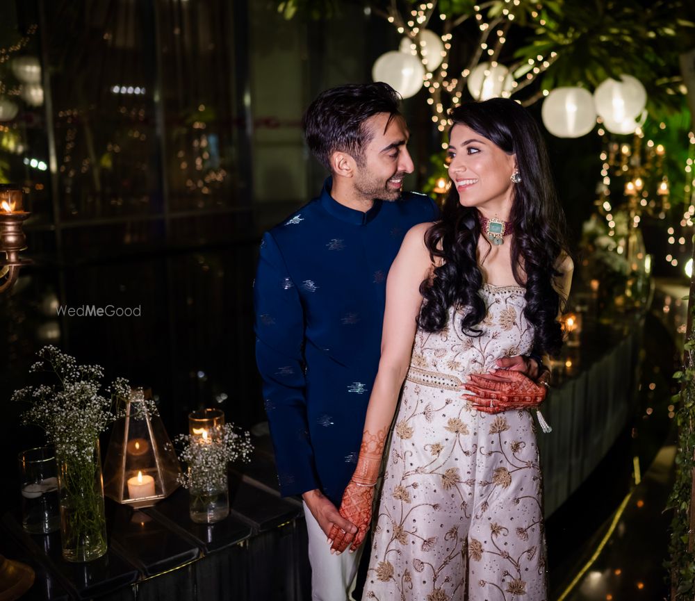 Photo of Couple posing on their engagement night in white jumpsuit and navy blue waistcoat