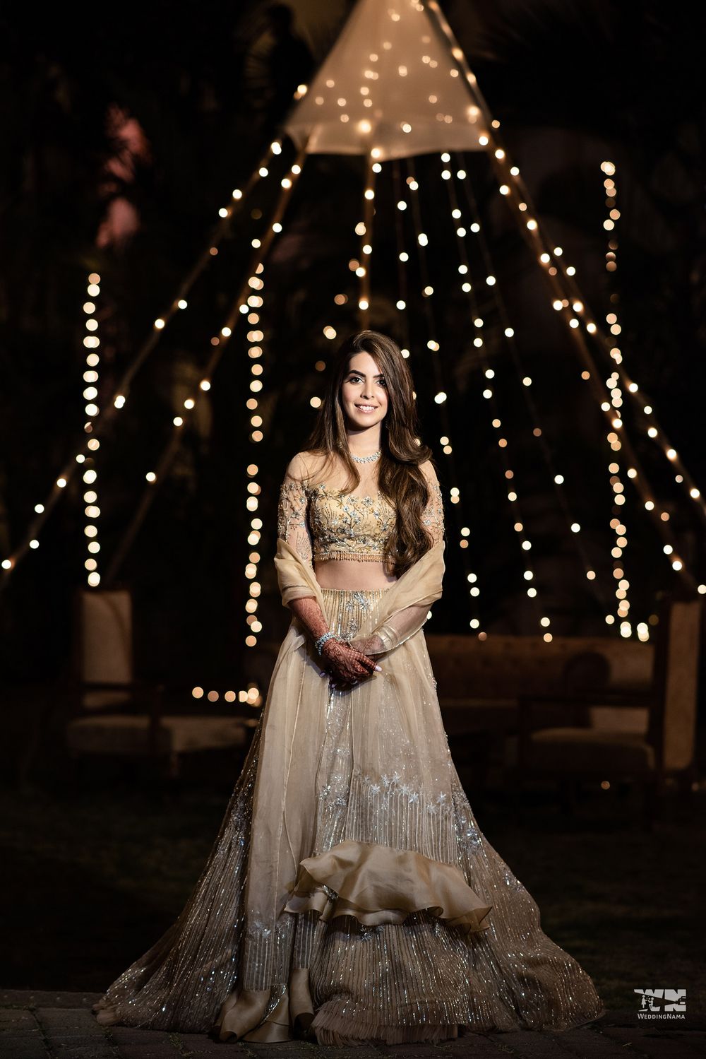 Photo of A bride in a tasseled gold lehenga for her sangeet