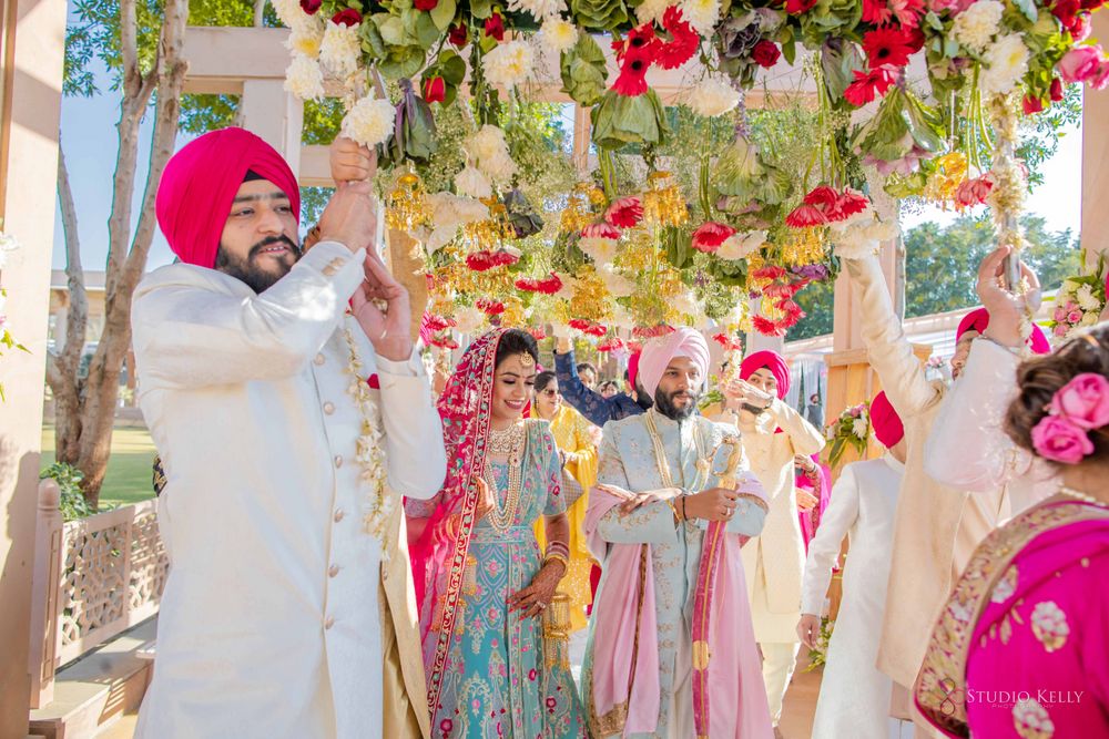 Photo of bride and groom entering under phoolon ki chadar