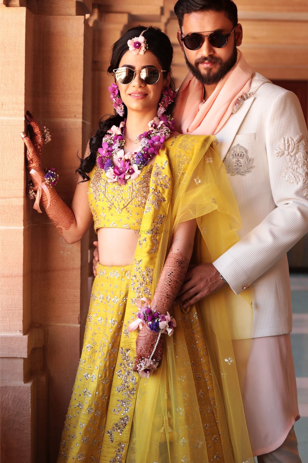 Photo of Bride and groom on mehendi wearing sunglasses