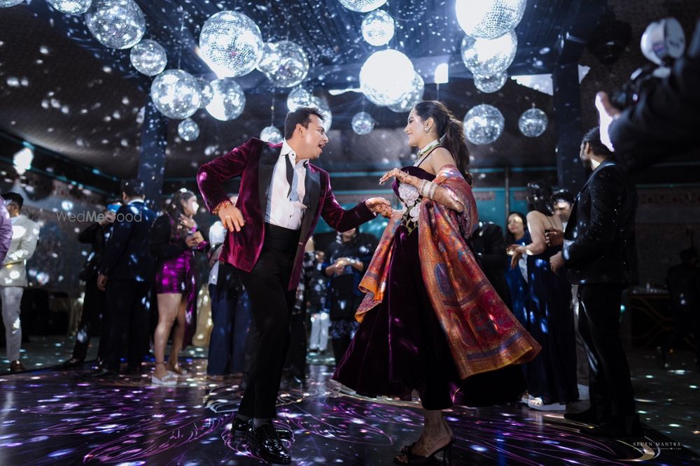 Photo of Fun dancing shot of the couple on their cocktail night with disco balls theme