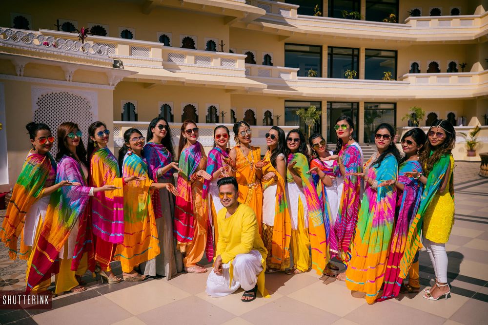 Photo of Groom with bridesmaids wearing leheriya dupattas