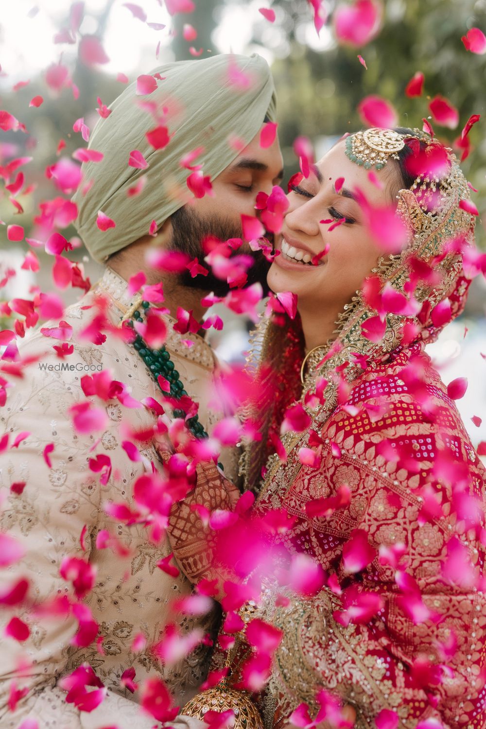 Photo of Beautiful just married shot of the couple under a shower of rose petals