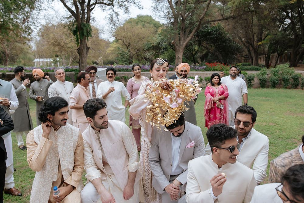 Photo of Fun photo of bride dropping kaleeras on her brothers and bridesmaids