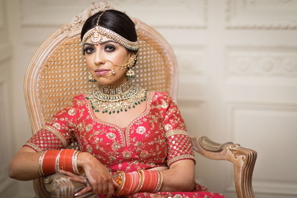 Photo of A bride in a red lehenga with a gold choker