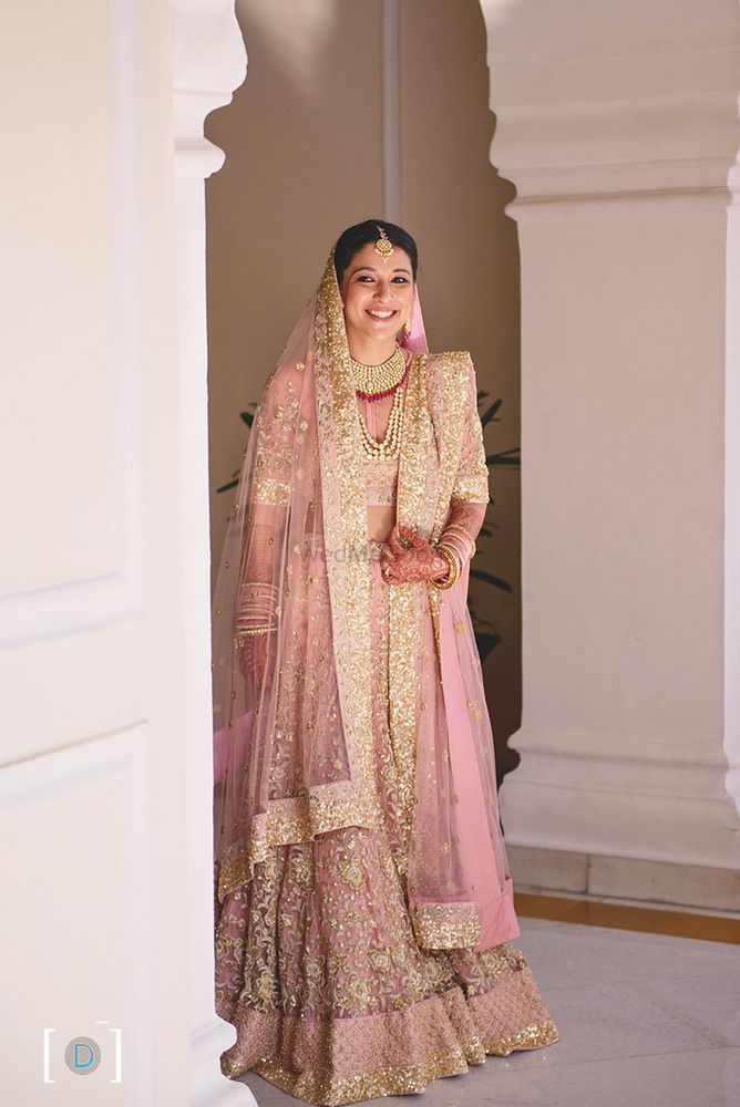 Photo of Bride in light pink and gold sequin work lehenga