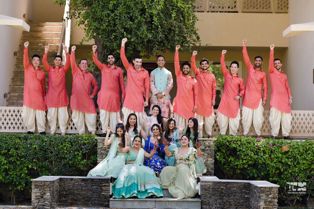 Photo of bride and groom with their bridesmaids and groomsmen on the mehendi