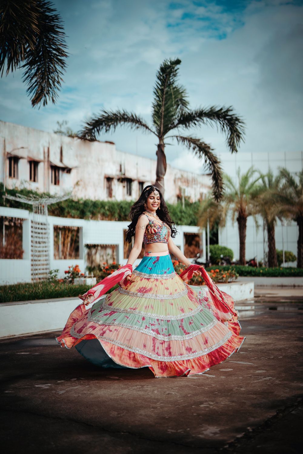 Photo of Bride twirling in a colorful Mehndi lehenga