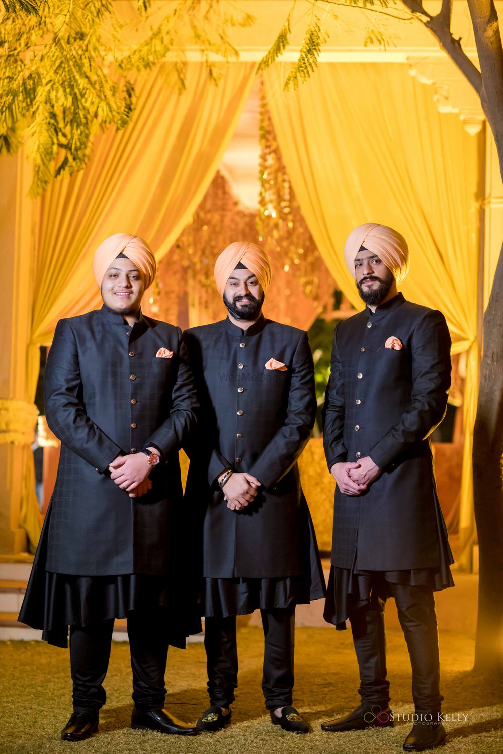 Photo of groomsmen in black sherwani with peach peach safa