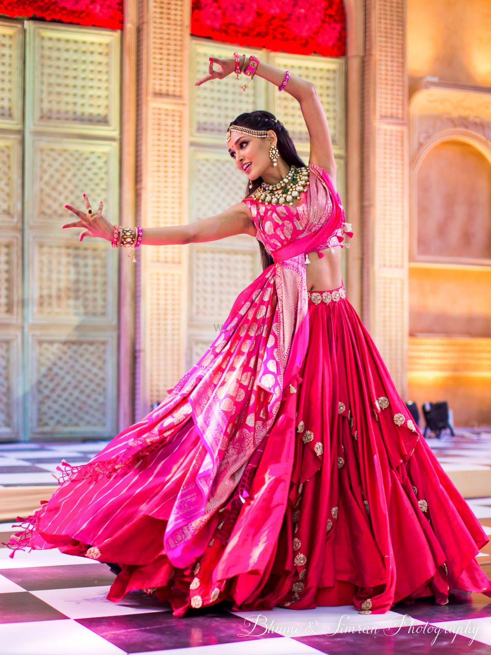 Photo of A bride in a unique mehndi outfit dancing on the stage