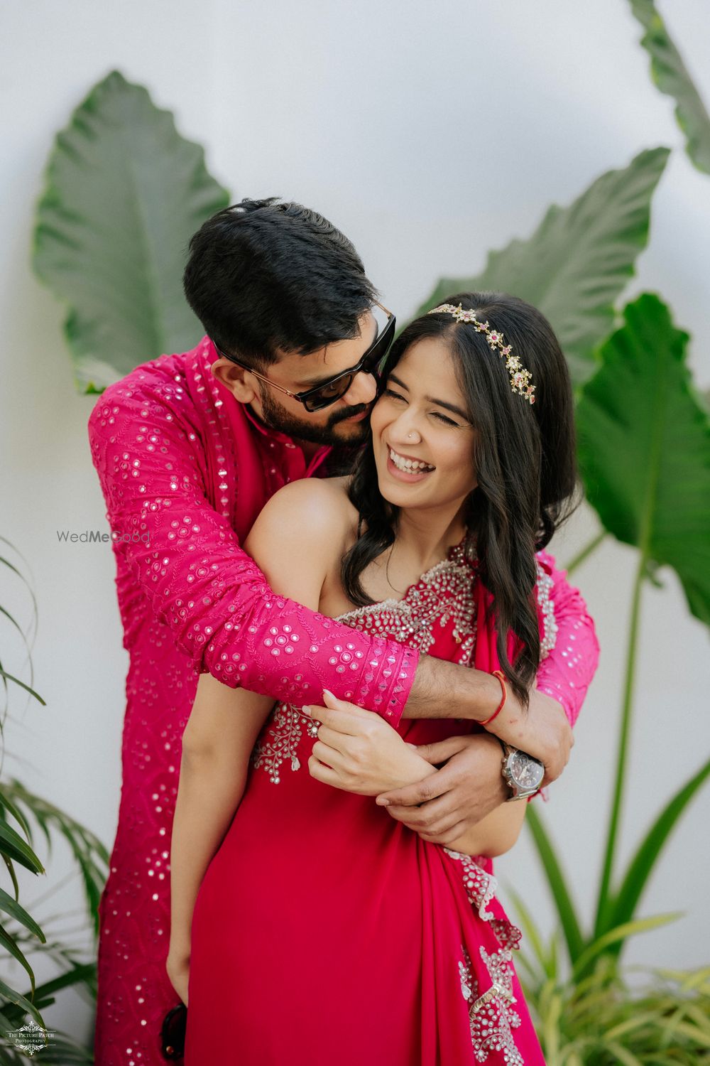 Photo of Bride and groom co-ordinated in matching pink outfits for the mehendi