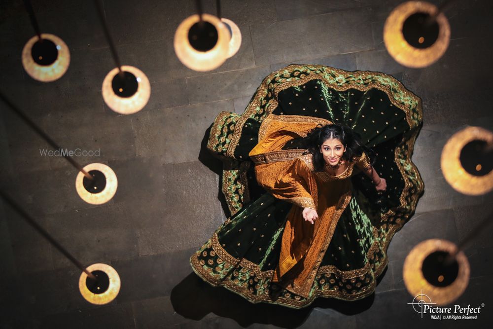 Photo of twirling bride shot in velvet lehenga