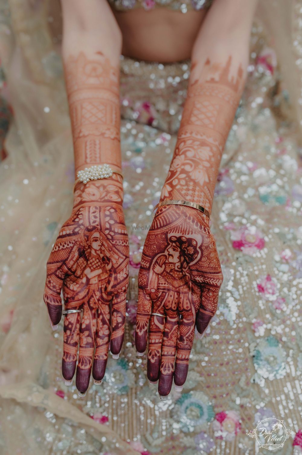 Photo of bridal mehendi design with bride and groom portraits
