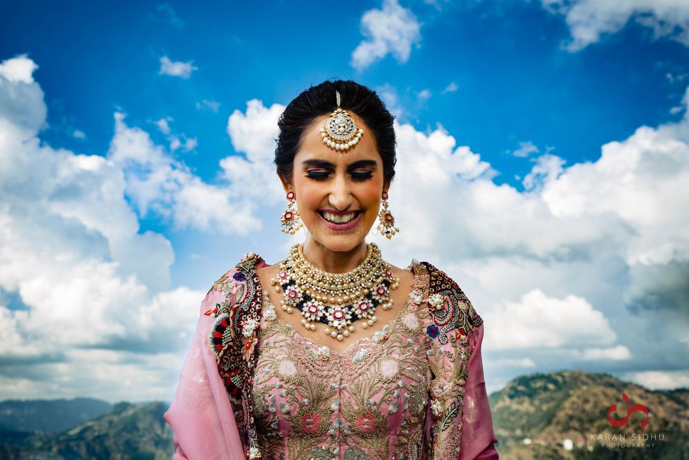 Photo of Bride in pink lehenga and contrasting blue jewellery