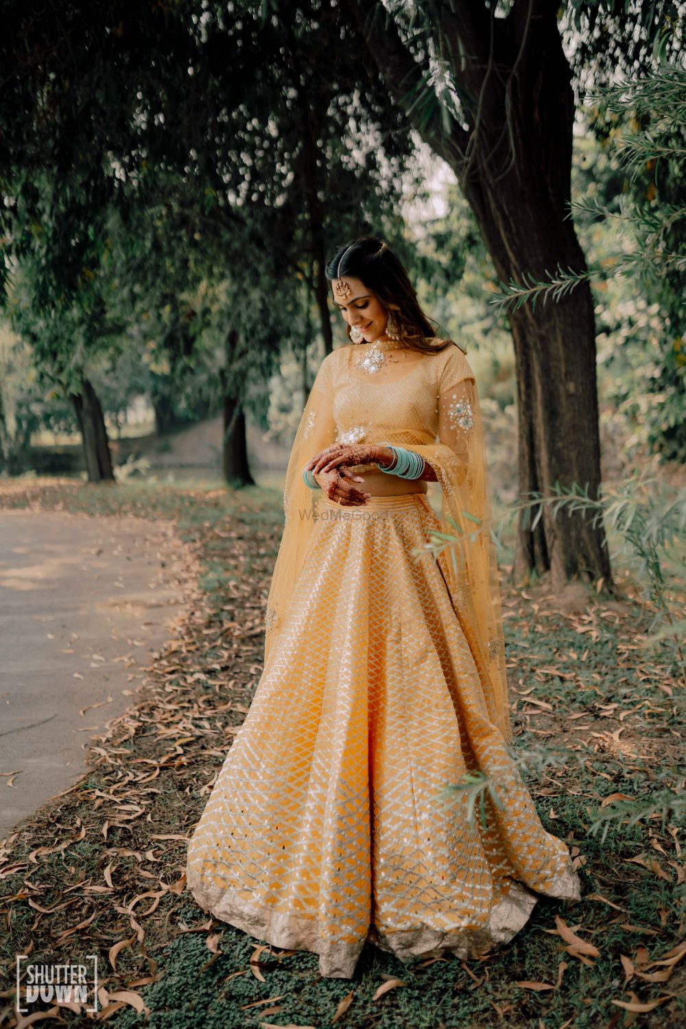 Photo of Bride in a yellow lehenga on mehendi