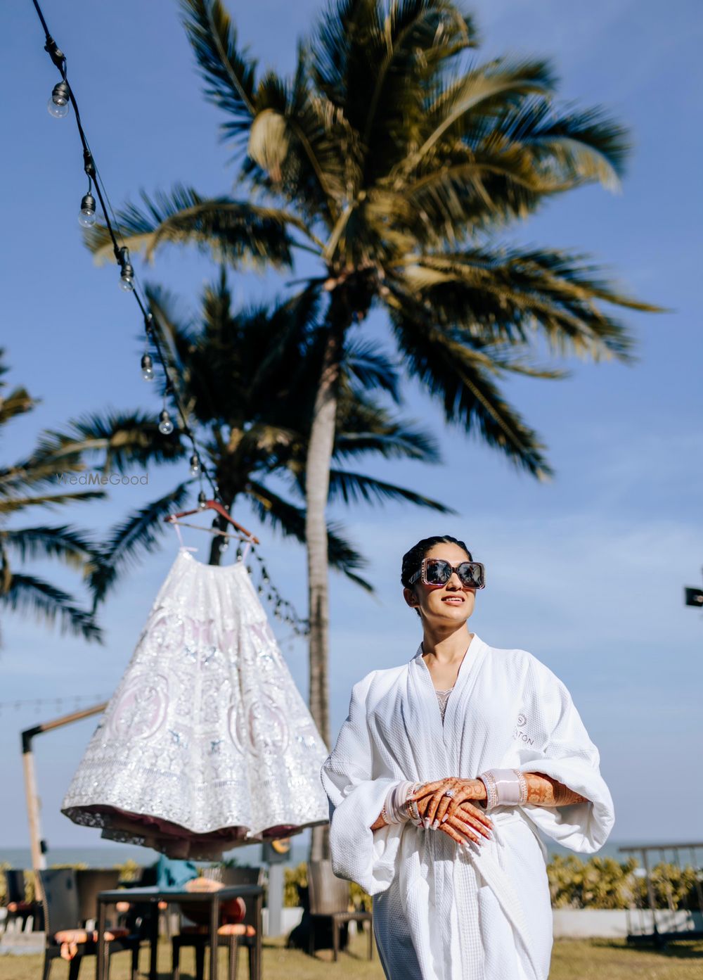 Photo of Bride in robe with lehenga on hanger getting ready shot idea