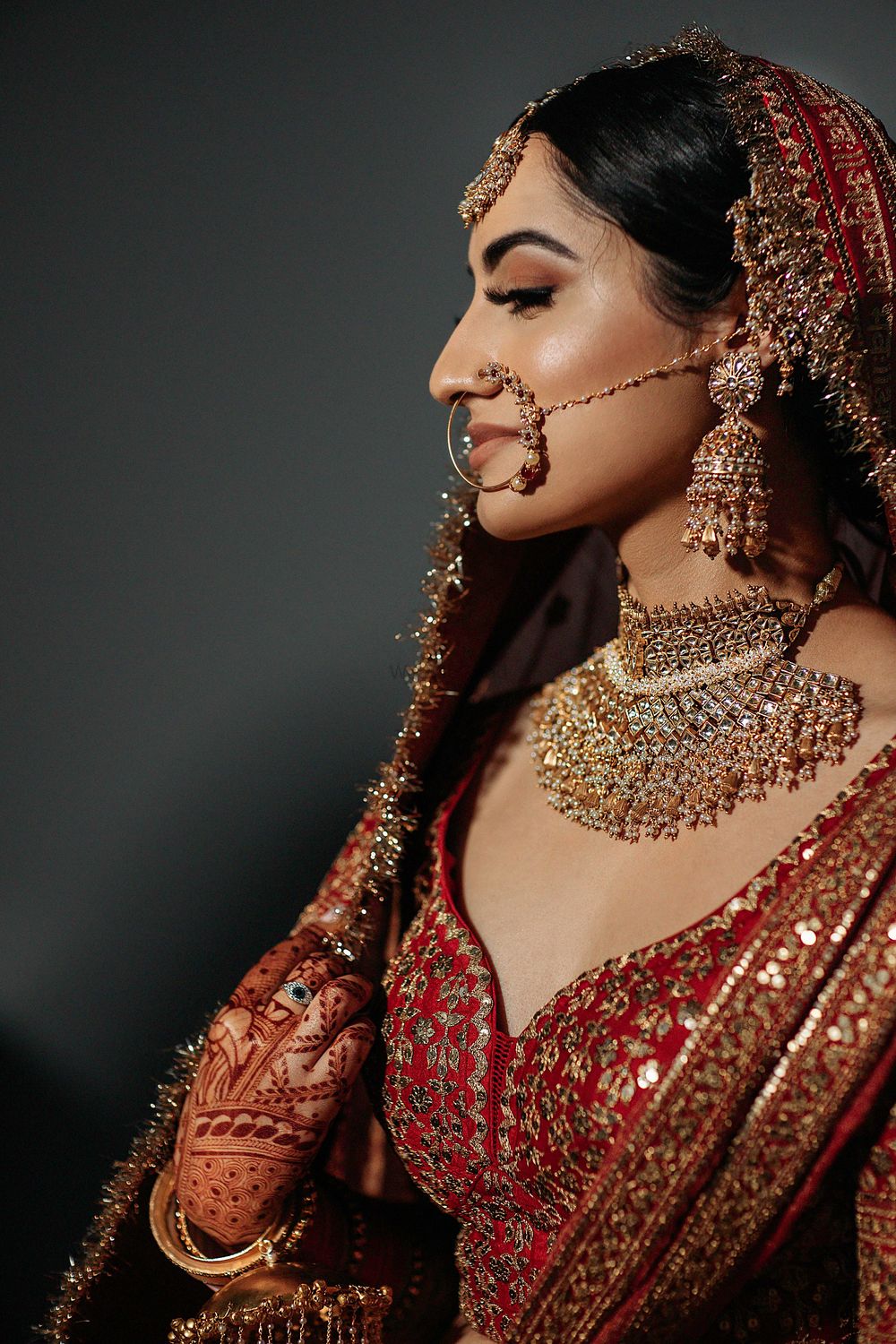 Photo of Bride wearing a red lehenga with a statement choker set