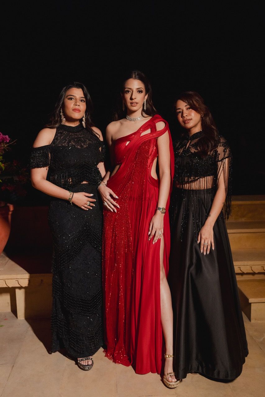 Photo of Co-ordinated bridesmaids on cocktail sangeet night with bride in red structured gown