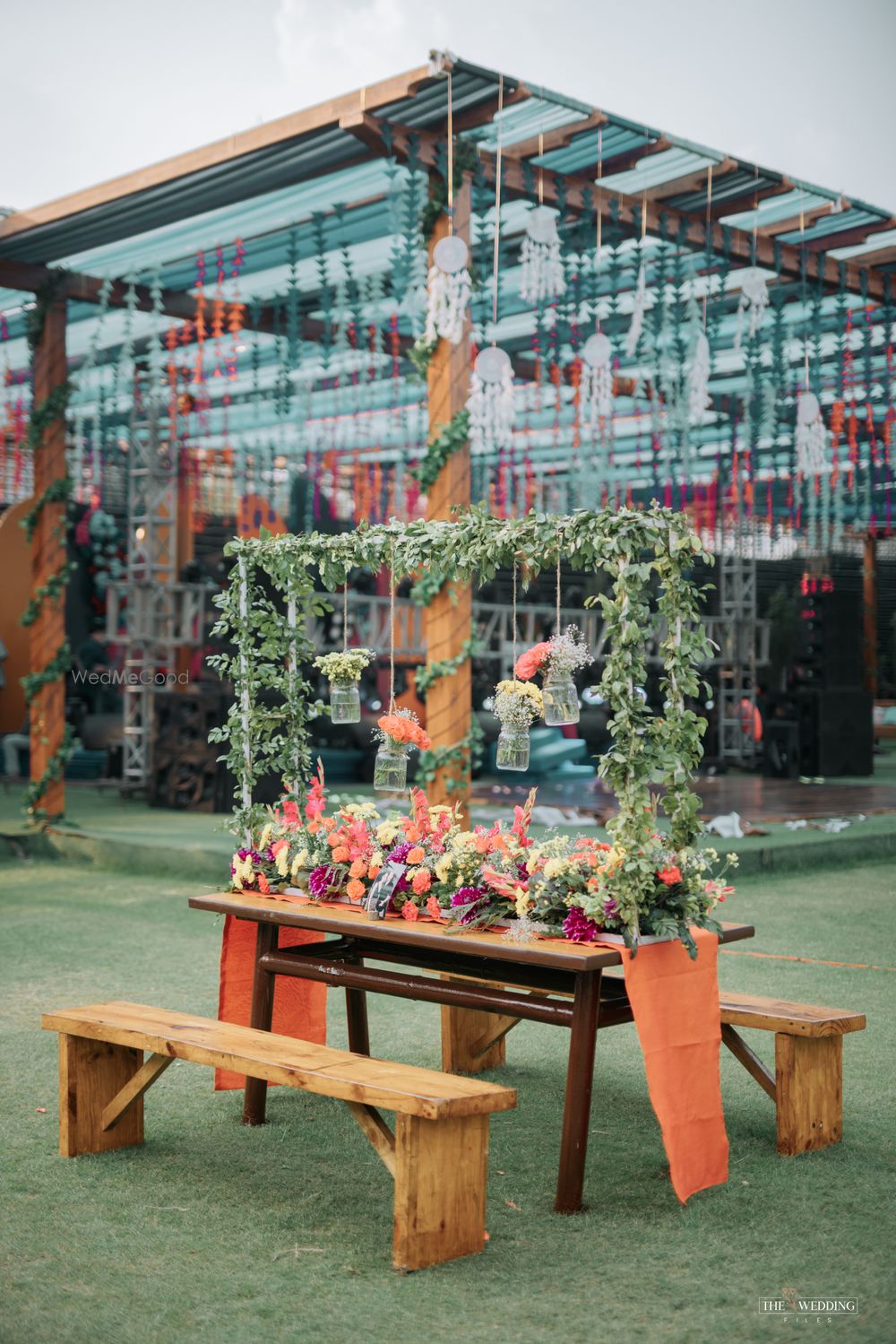 Photo of floral hanging bottles decor with floral table centerpiece