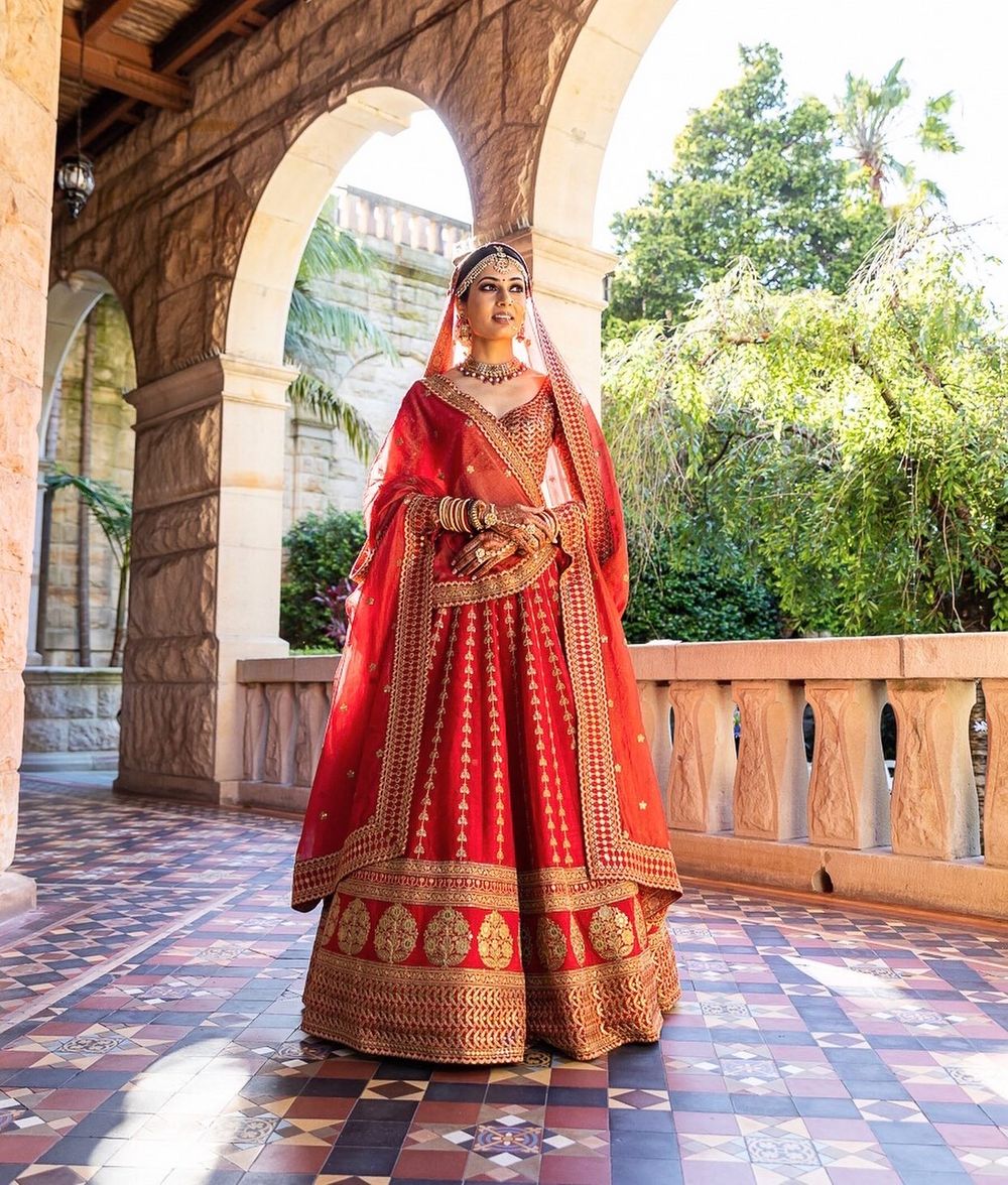 Photo of timeless red and gold designer bridal lehenga
