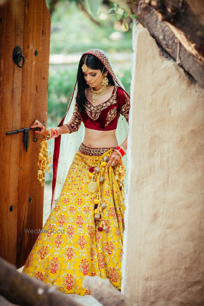 Photo of Yellow silk bridal lehenga with maroon velvet blouse