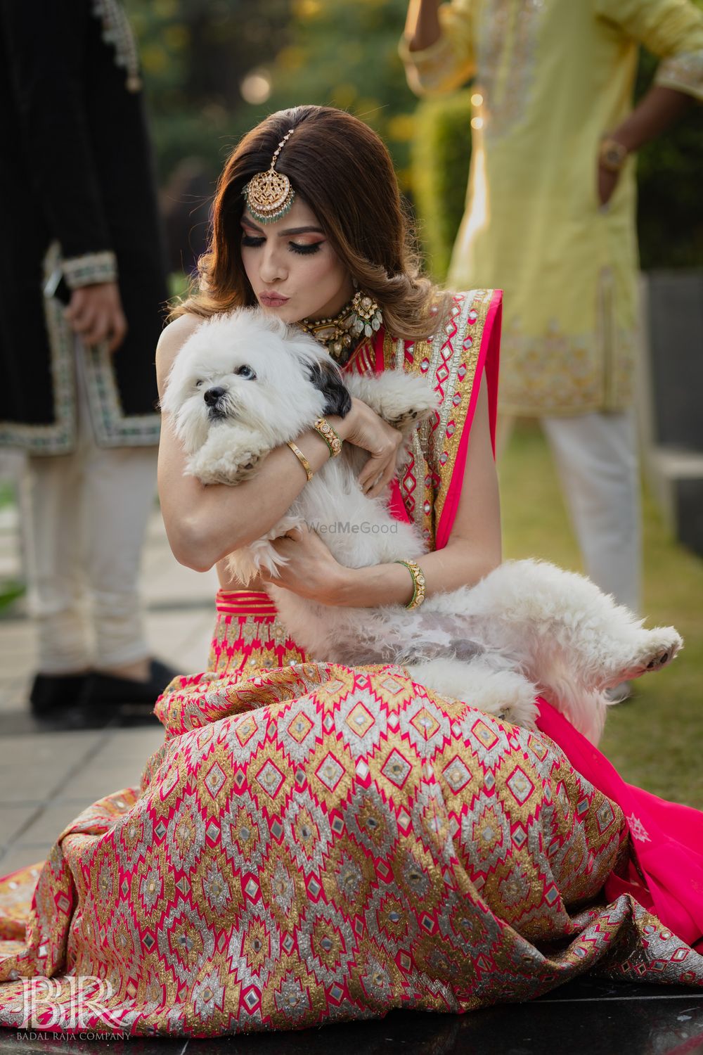 Photo of cute portrait of bride in pink lehenga with her dog