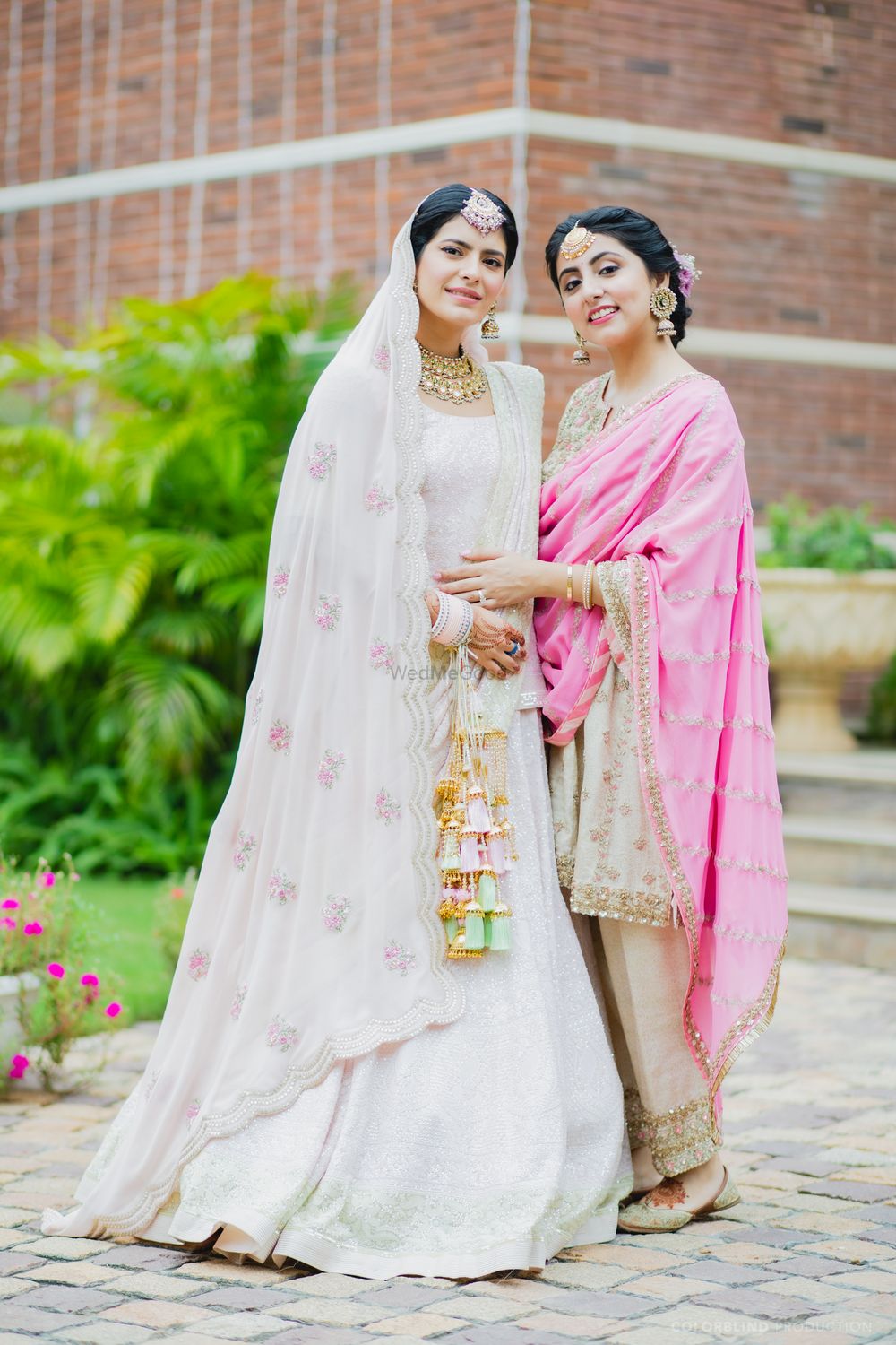 Photo of pastel pink sikh bride with her sister before the wedding