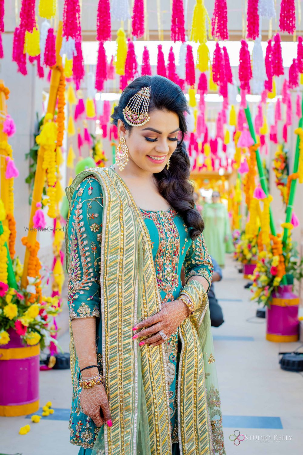 Photo of happy bridal mehendi look with suit and jhoomar