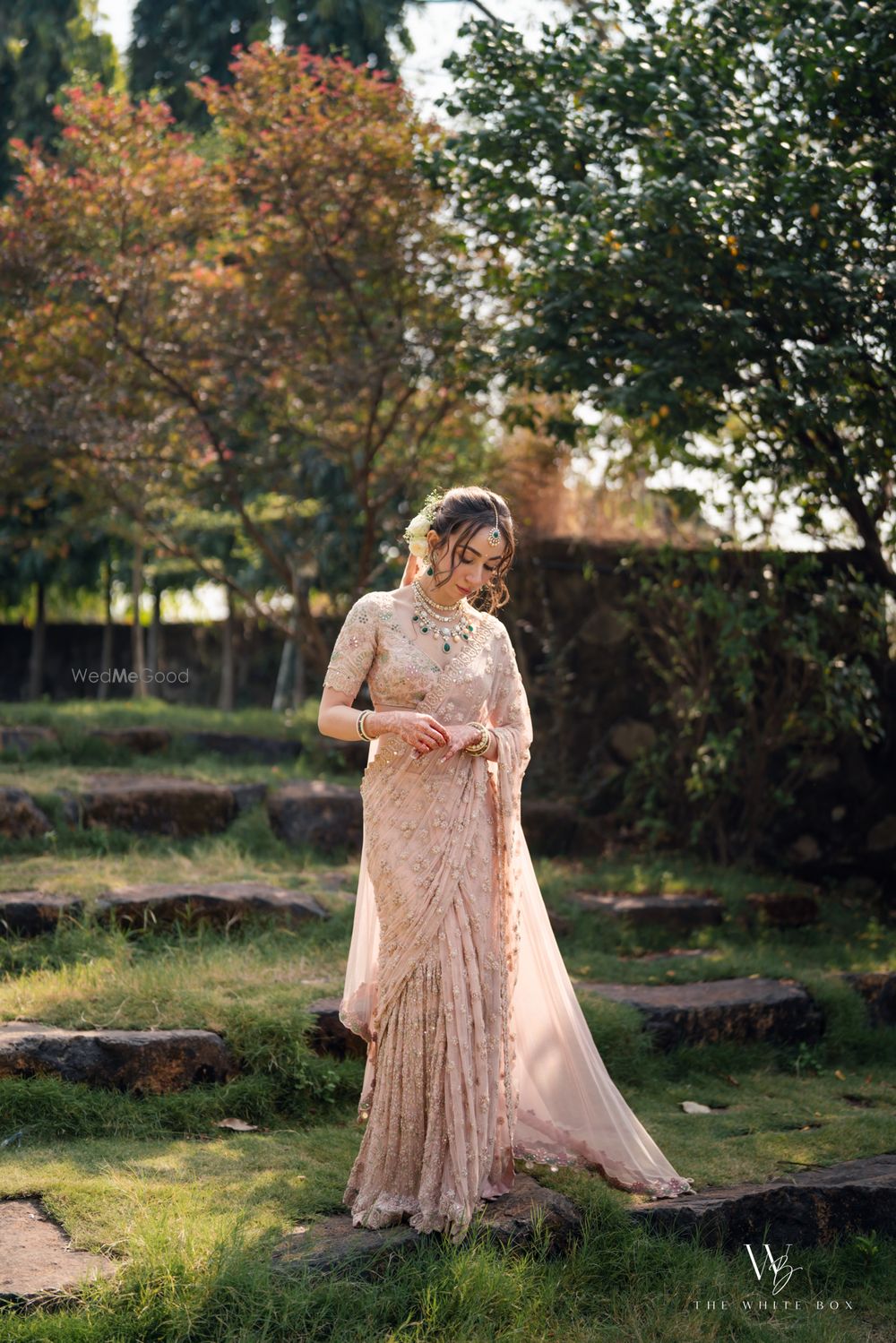 Photo of Gorgeous wedding day bridal portrait with the bride in a peach saree and emerald jewels