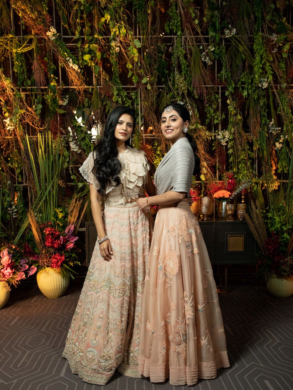 Photo of bride with her sister wearing a unique silver blouse