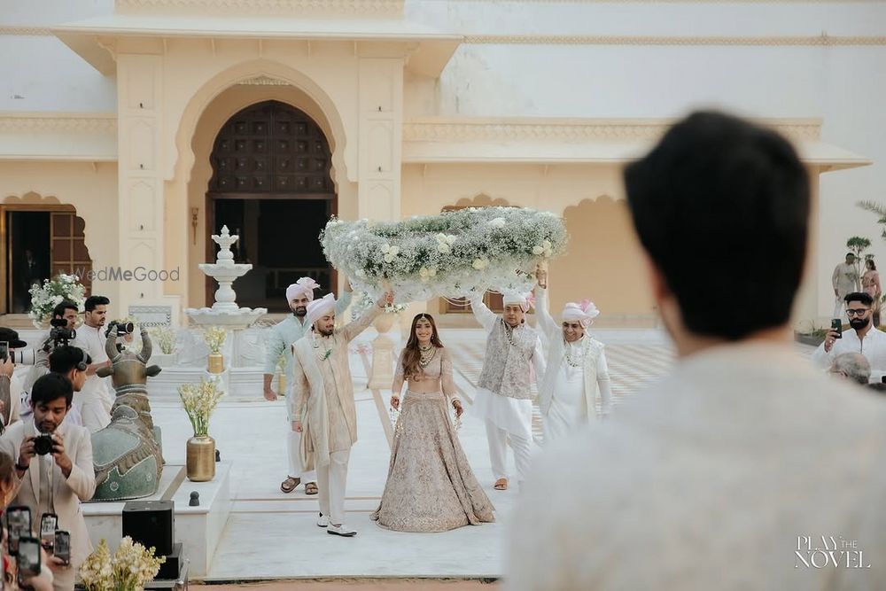 Photo of Gorgeous entry shot of the bride under phoolon ki chaadar with her brothers in a pastel theme wedding