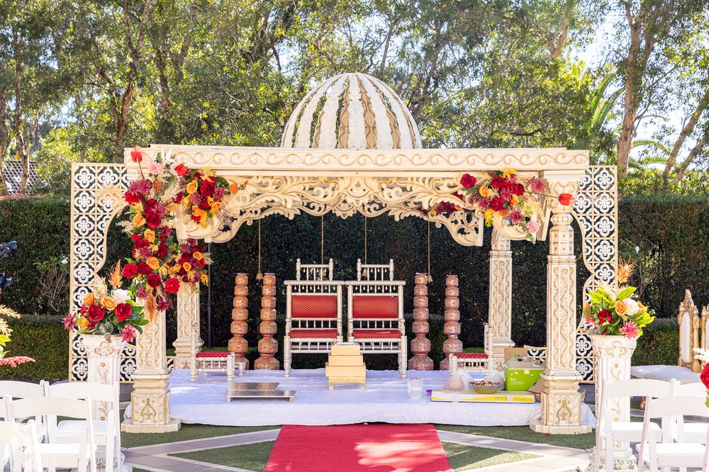Photo of white outdoor mandap with floral arrangement