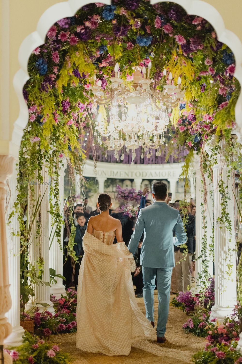 Photo of Gorgeous mixed floral decor with the couple entering for their rehearsal dinner