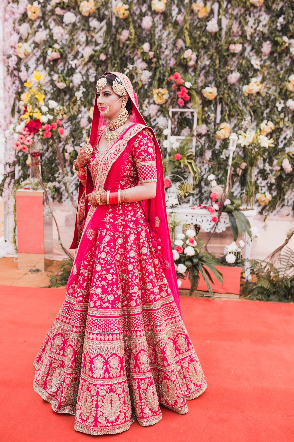 Photo of A bride in a raani pink lehenga for her wedding