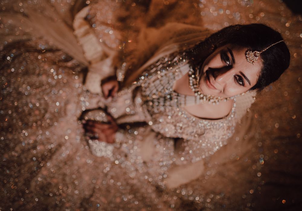 Photo of Bride sitting in a beautiful lehenga flared on the floor.