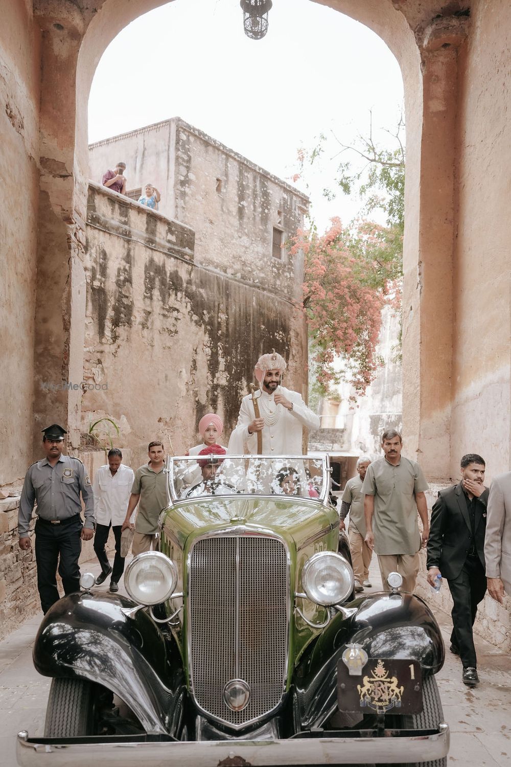Photo of Royal entry for the groom in an olive green vinatge car